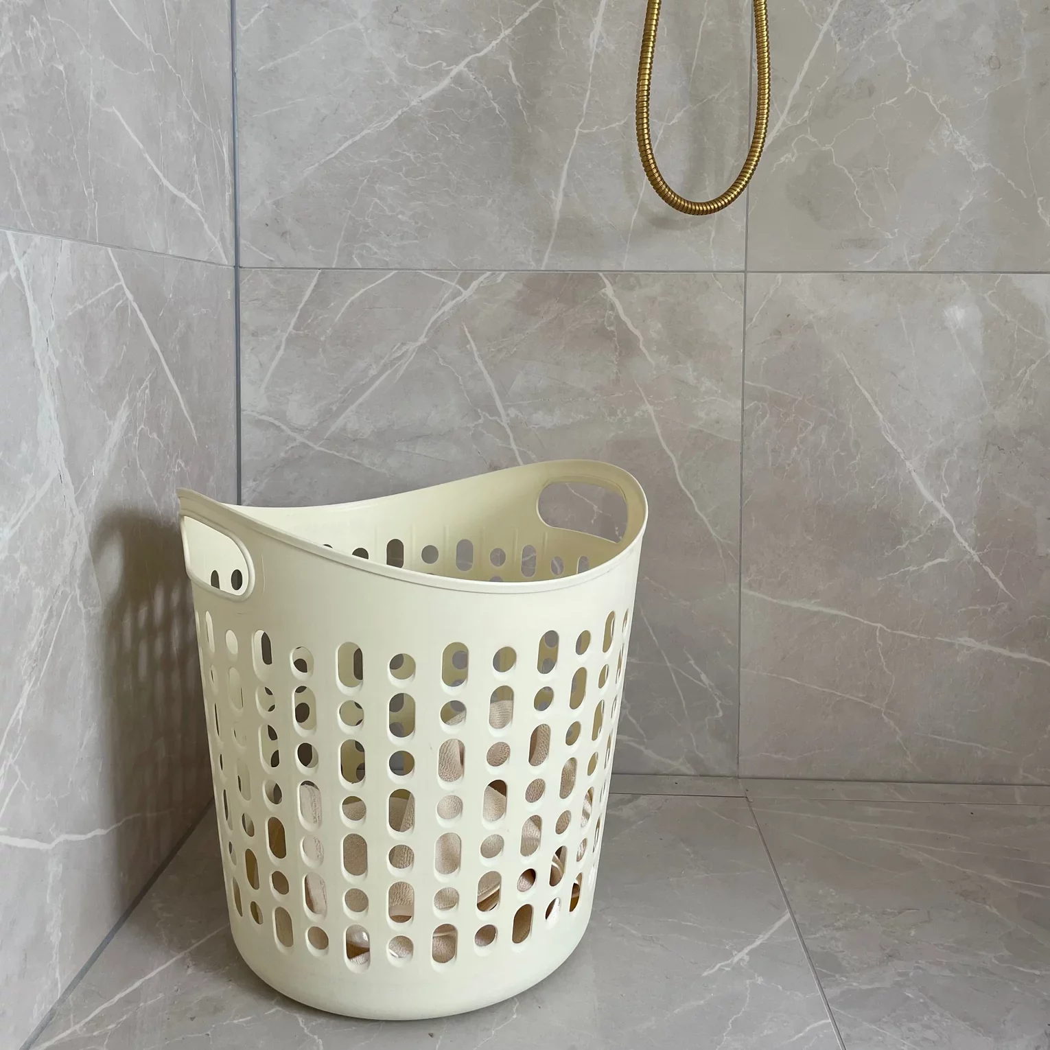 Wasmand met handels van humdakin in off-white plastic in wasruimte