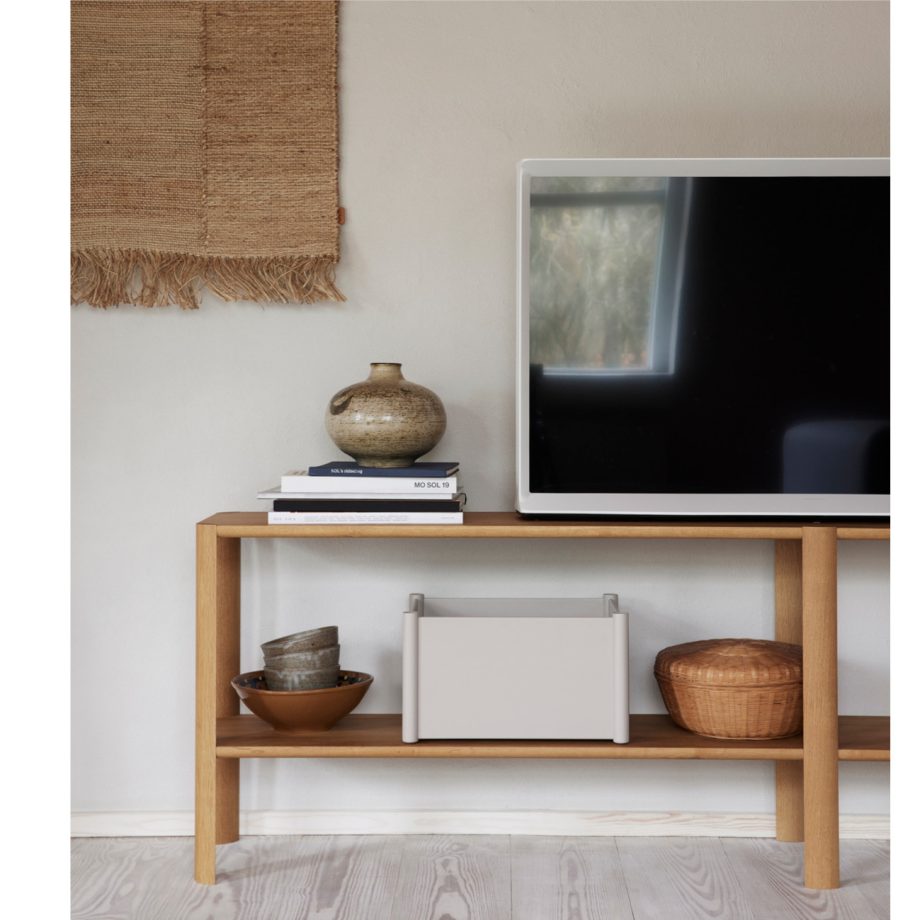 Form & Refine Leaf kast in wit eikenhout, gebruikt als stijlvolle TV-meubel. Gestyled met keramische decoratie, boeken en opbergaccessoires voor een minimalistisch en natuurlijk interieurontwerp.