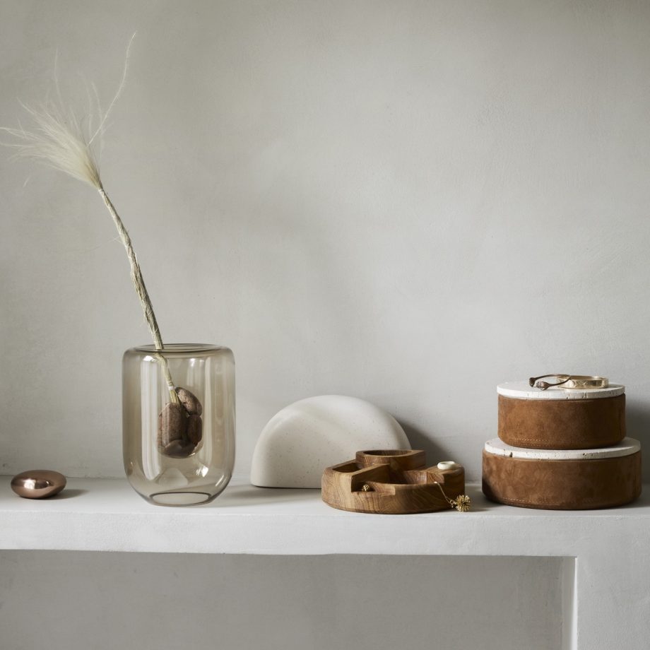 Minimalistische interieursetting met een Kristina Dam Studio vaas, houten opbergdozen en stenen decoratie. De combinatie van natuurlijke materialen en zachte tinten creëert een rustige en stijlvolle uitstraling voor de badkamer of woonkamer