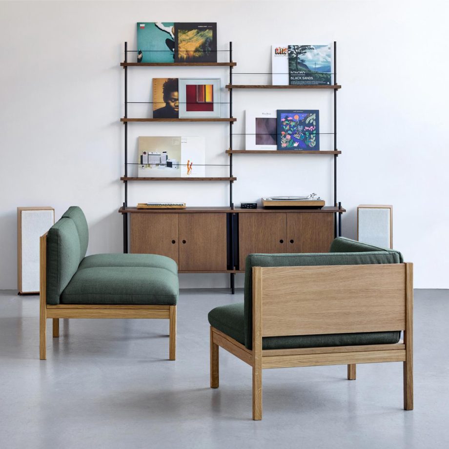 Modulaire bank en lounge stoelen van Moebe met een massief eiken frame en diepe groene stoffering, gecombineerd met een stijlvol wandrek en opbergmeubel. Een perfect design voor een moderne en flexibele woonruimte.