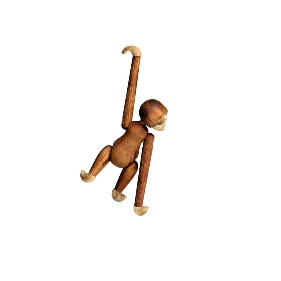 De Kay Bojesen Mini Monkey, een charmant en handgemaakt houten aapje, bungelt speels aan één arm. Gemaakt van teakhout en limbahout, met beweegbare ledematen, een tijdloos Scandinavisch design en een geliefd interieuraccessoire.