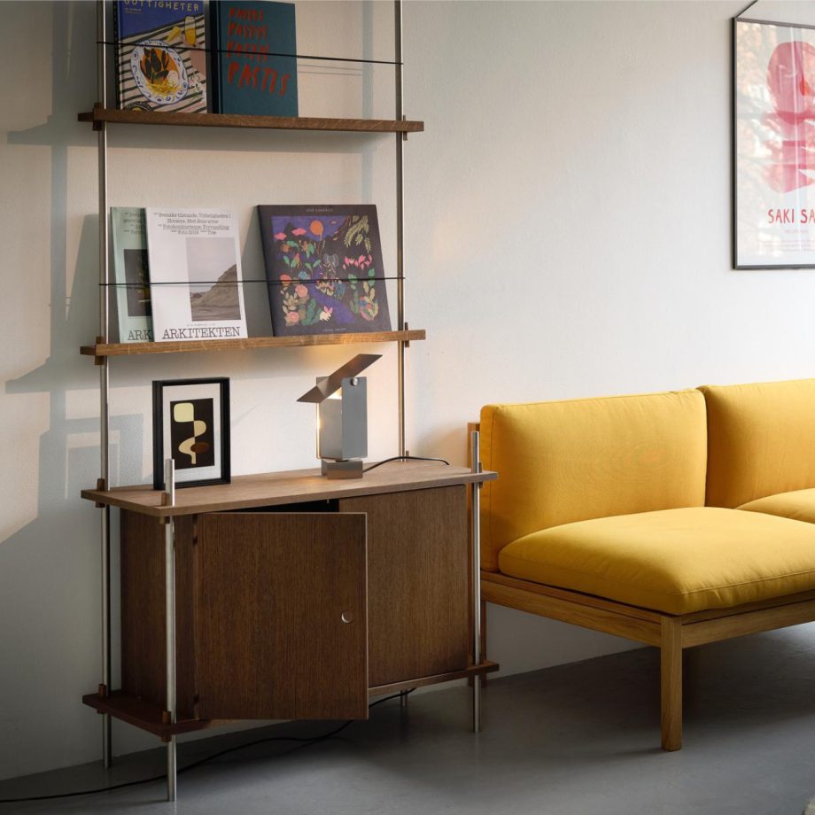 Stalen leeslamp in Moebe woonkamer met shelving system kast en modular sofa.