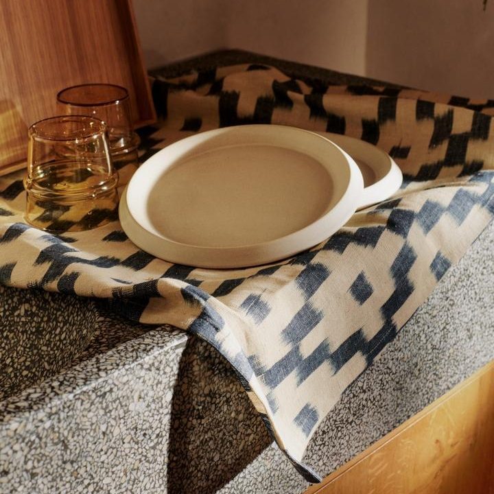 Servies op Ferm Living Ikat keukendoek in ink blue en off-white met Erena side plates en Boya glazen op terrazzo aanrecht