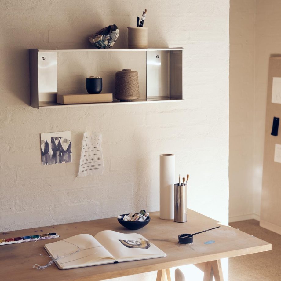 Taper stalen wandrek van Form & Refine hangend boven houten bureau in kantoorsfeer