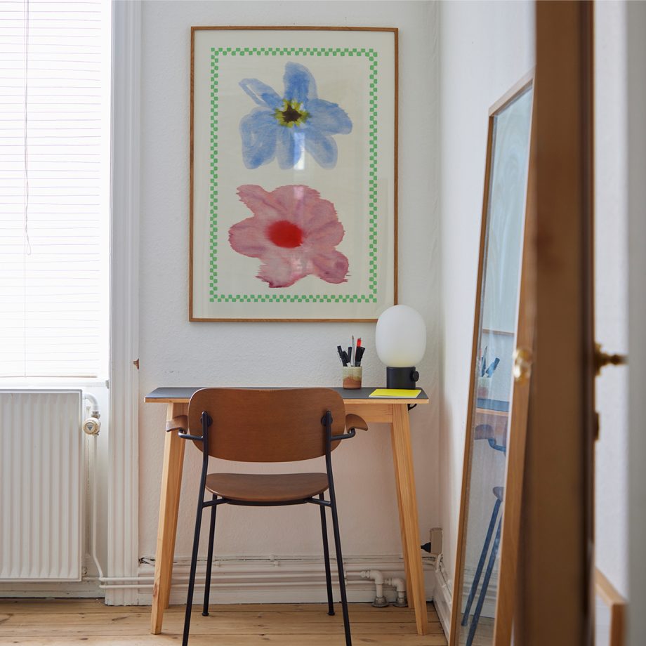 Paper Collective poster in retro design pastelkleuren boven bureau in kantoor.