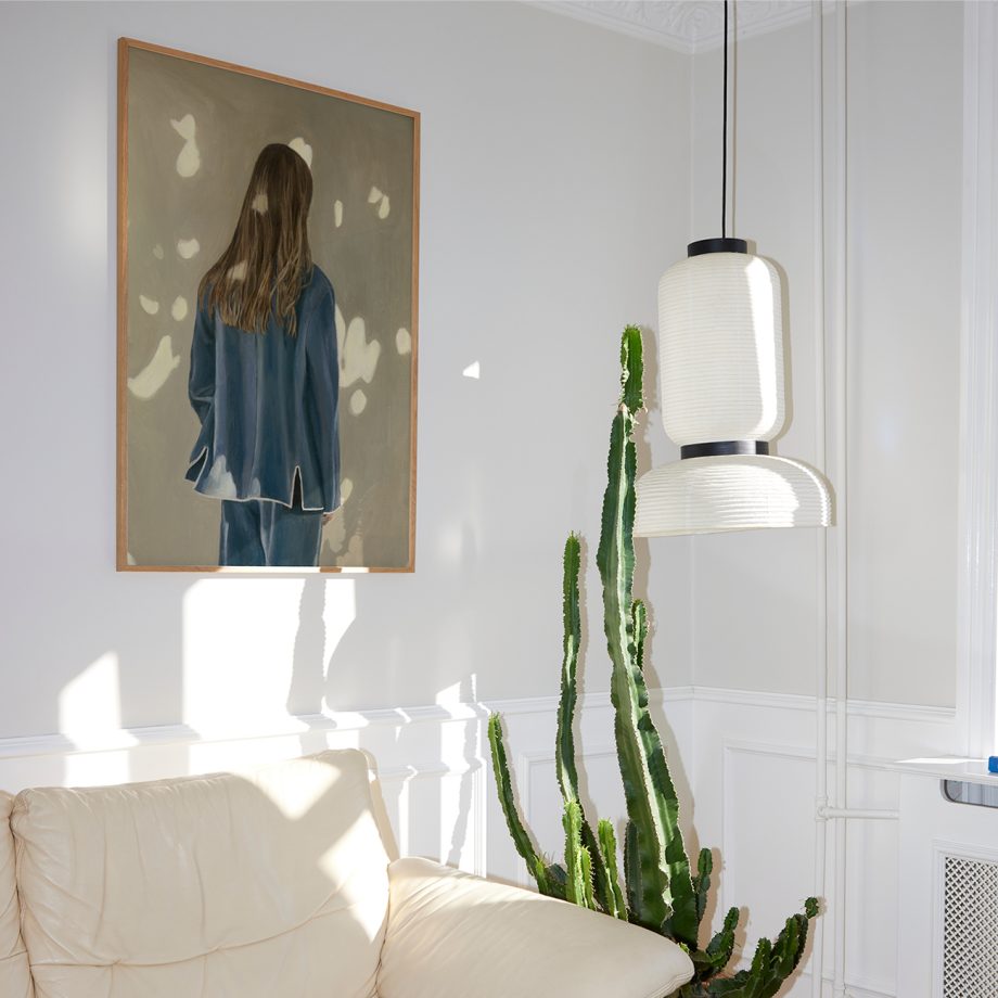 Paper Collective kunstposter Light and Shadow met een vrouw in natuurlijke beige bruine en blauwe tinten in een lichte woonkamer