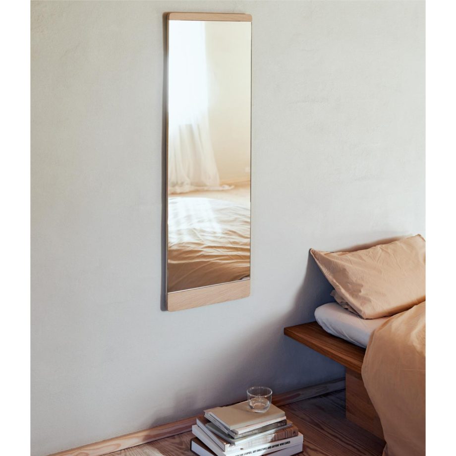 Stijlvolle en tijdloze hangende spiegel in rustige japans Scandinavische slaapkamer