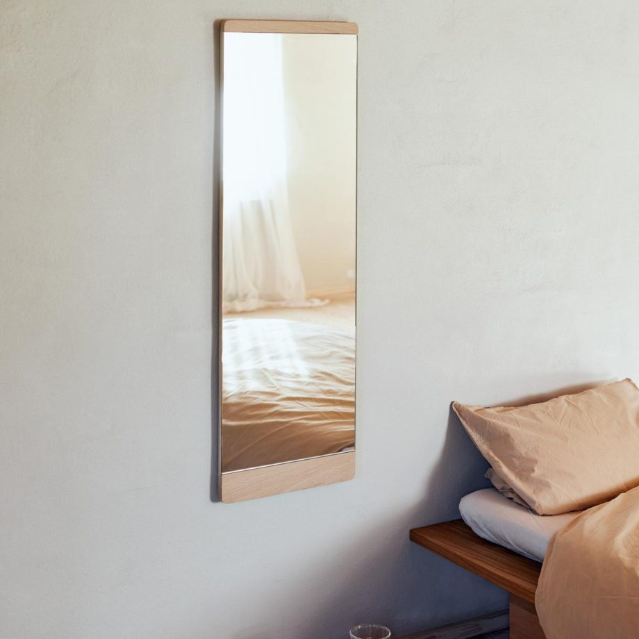 Lange Rim Passpiegel van Form & Refine met een naturel eikenhouten frame in de slaapkamer