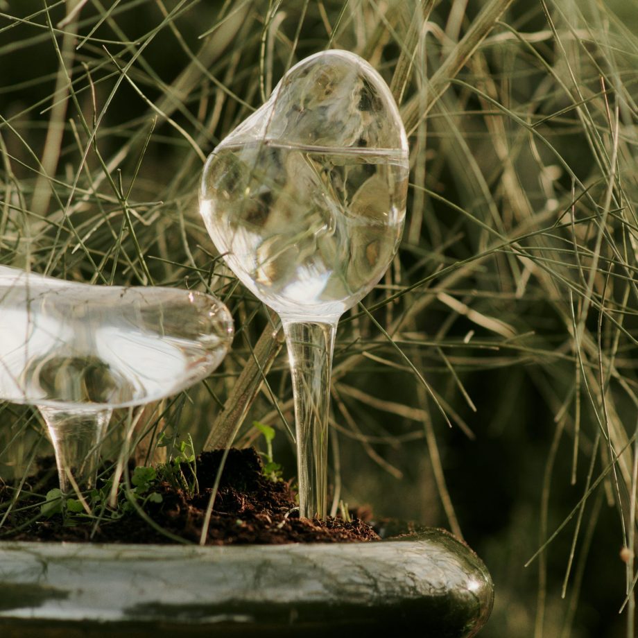 Twee glazen Ferm Living waterdruppelaars organische form in een plantenbak