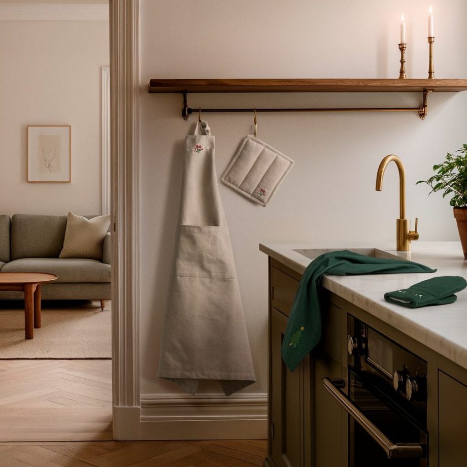 Scandinavische keuken met zandkleurige schort en pannenlap van Juna hangend aan haken