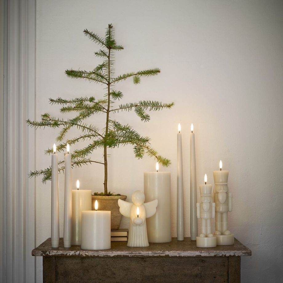 Kersttafel met verschillende led figuur kaarsen en led-dinarkaarsen in sfeervolle opstelling met een kerstboompje