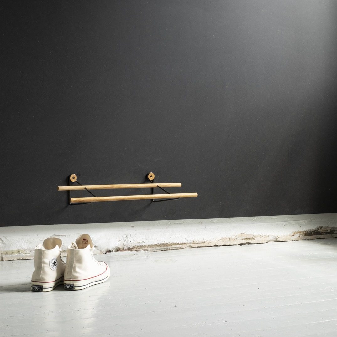 We Do Wood Schoenenrek in eikenhout en zwart metaal hangend om zwarte muur.